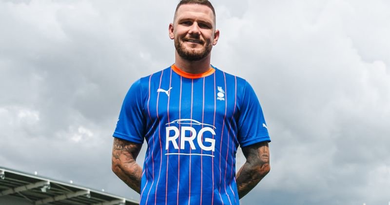 player wearing oldham athletic 2023-24 home shirt in blue and orange